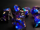 photographie d'un set de dés de jeux de rôle brillants violet bleu et noir